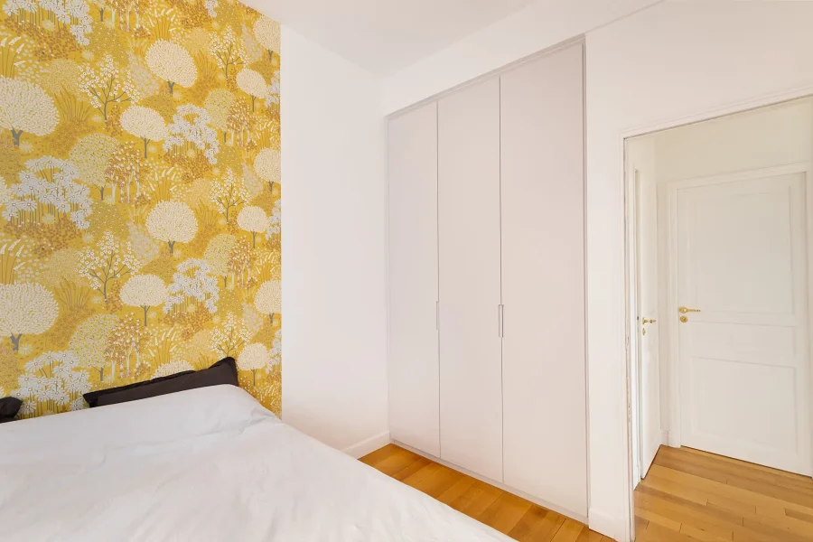 Armoire sur mesure encastrée dans un renfoncement avec façades blanches unies toute hauteur