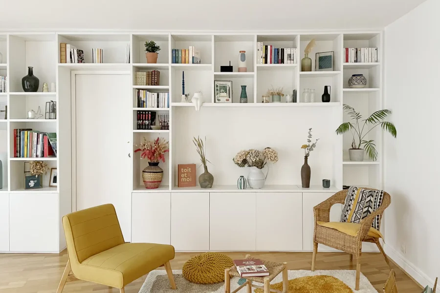 Détail des étagères ouvertes et rangements fermés d’une bibliothèque blanc laqué design