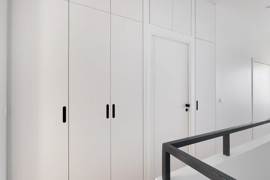 Vue latérale du dressing de couloir toute hauteur avec penderie, étagères réglables et tiroirs intégrés