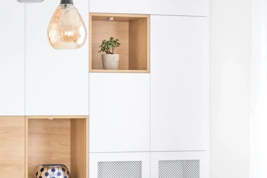 Rangements bas avec grilles métalliques ajourées intégrés autour du radiateur